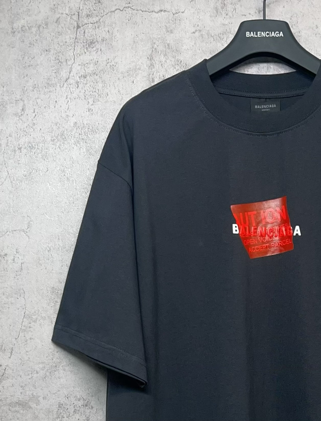 Balenciaga short-sleeve T-shirt, dark navy, red logo on chest, angled view