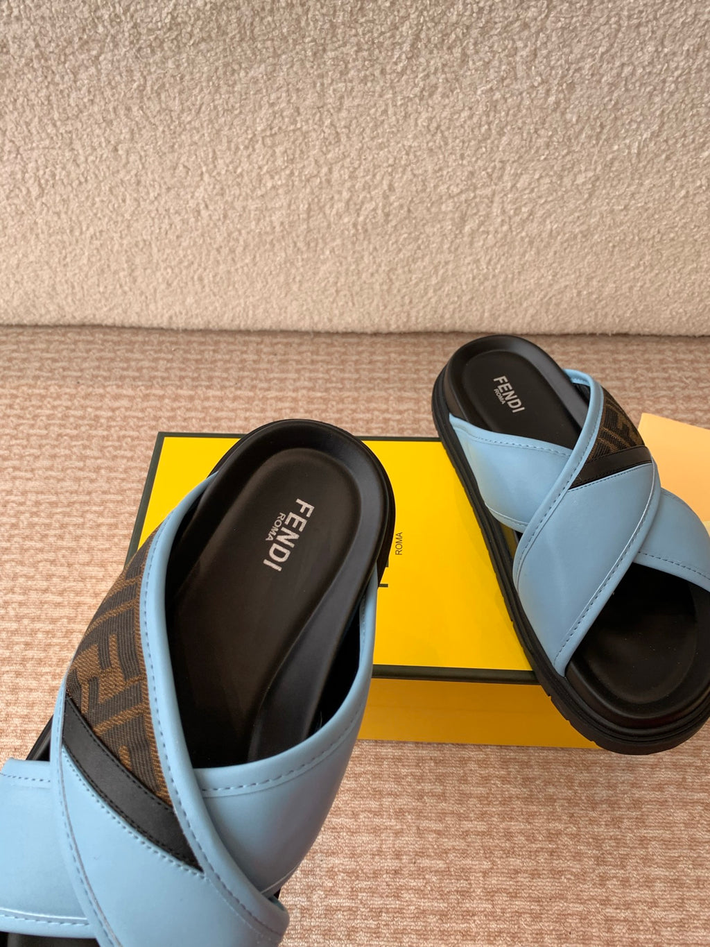 Light blue slide sandals with black-lined footbed and cross-strap detail