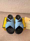 Fendi light blue slide sandals with crisscross straps and black rubber soles
