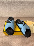 Light blue Fendi sandals with wide cross straps and black platform soles