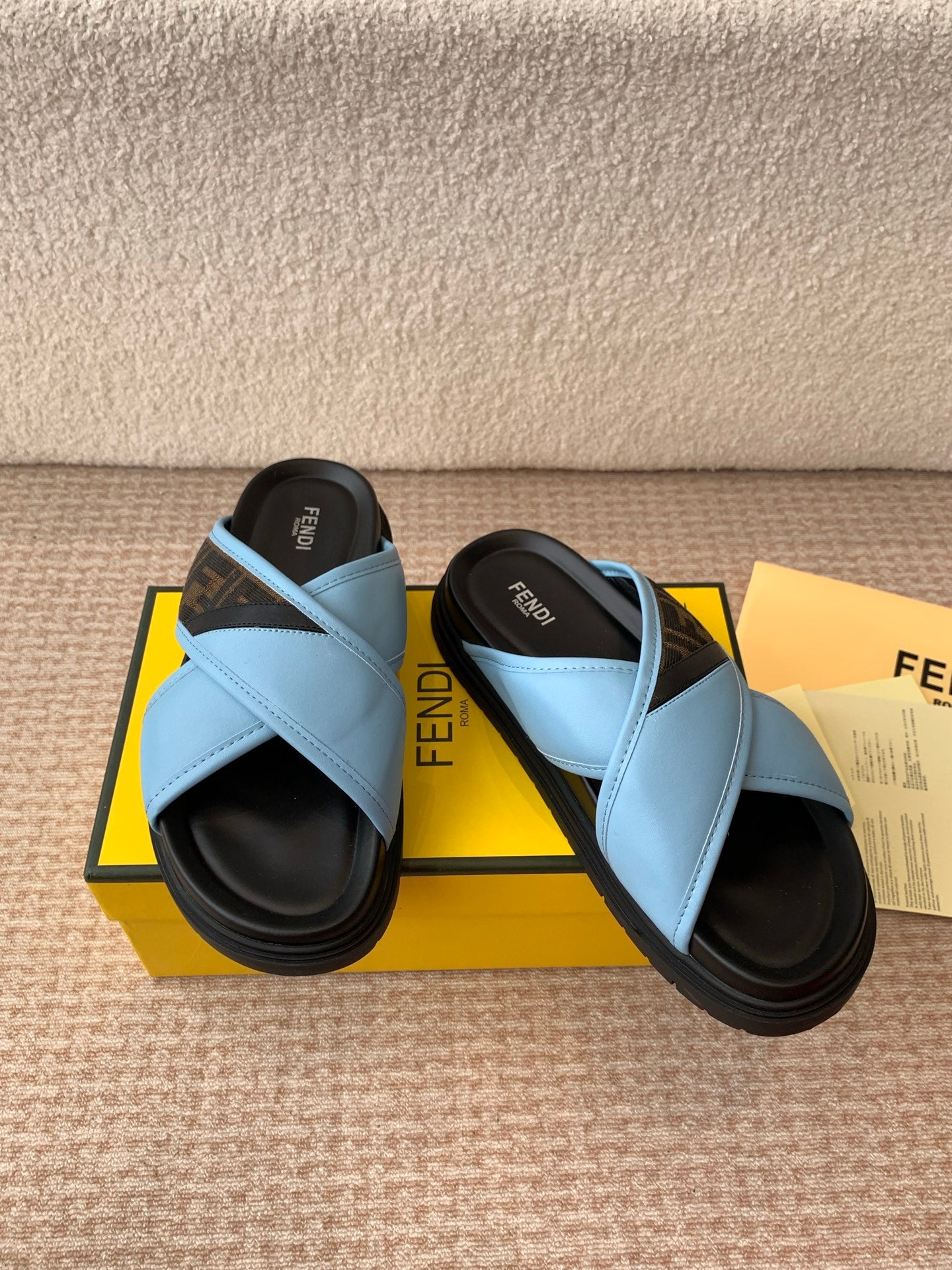 Light blue Fendi sandals with wide cross straps and black platform soles