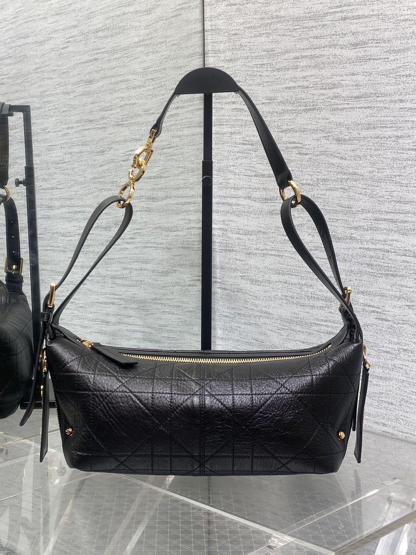 Black Dior quilted shoulder bag with gold-tone chain straps and zipper top