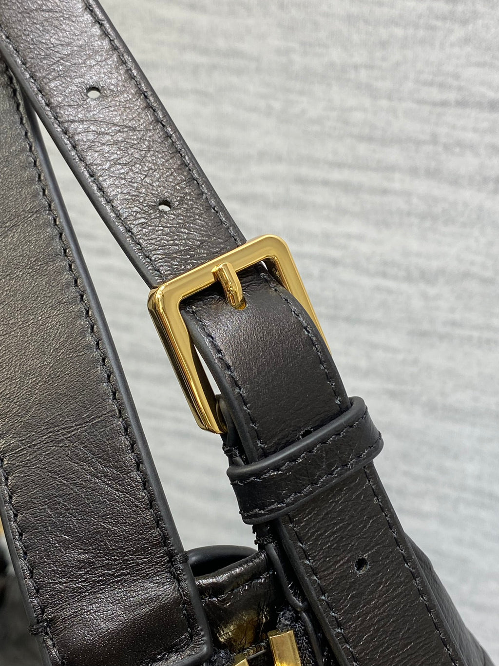 Black Dior leather strap with gold buckle and attachment hardware