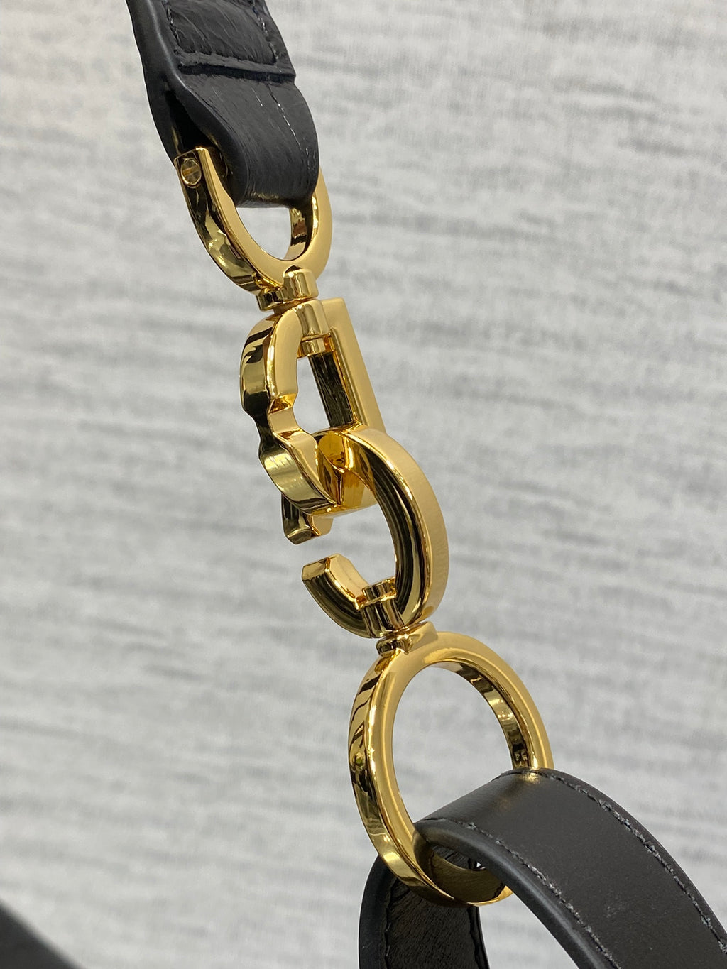 Gold-tone Dior clasp hardware on black strap with rounded link detail