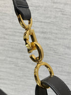 Gold-tone Dior clasp hardware on black strap with rounded link detail