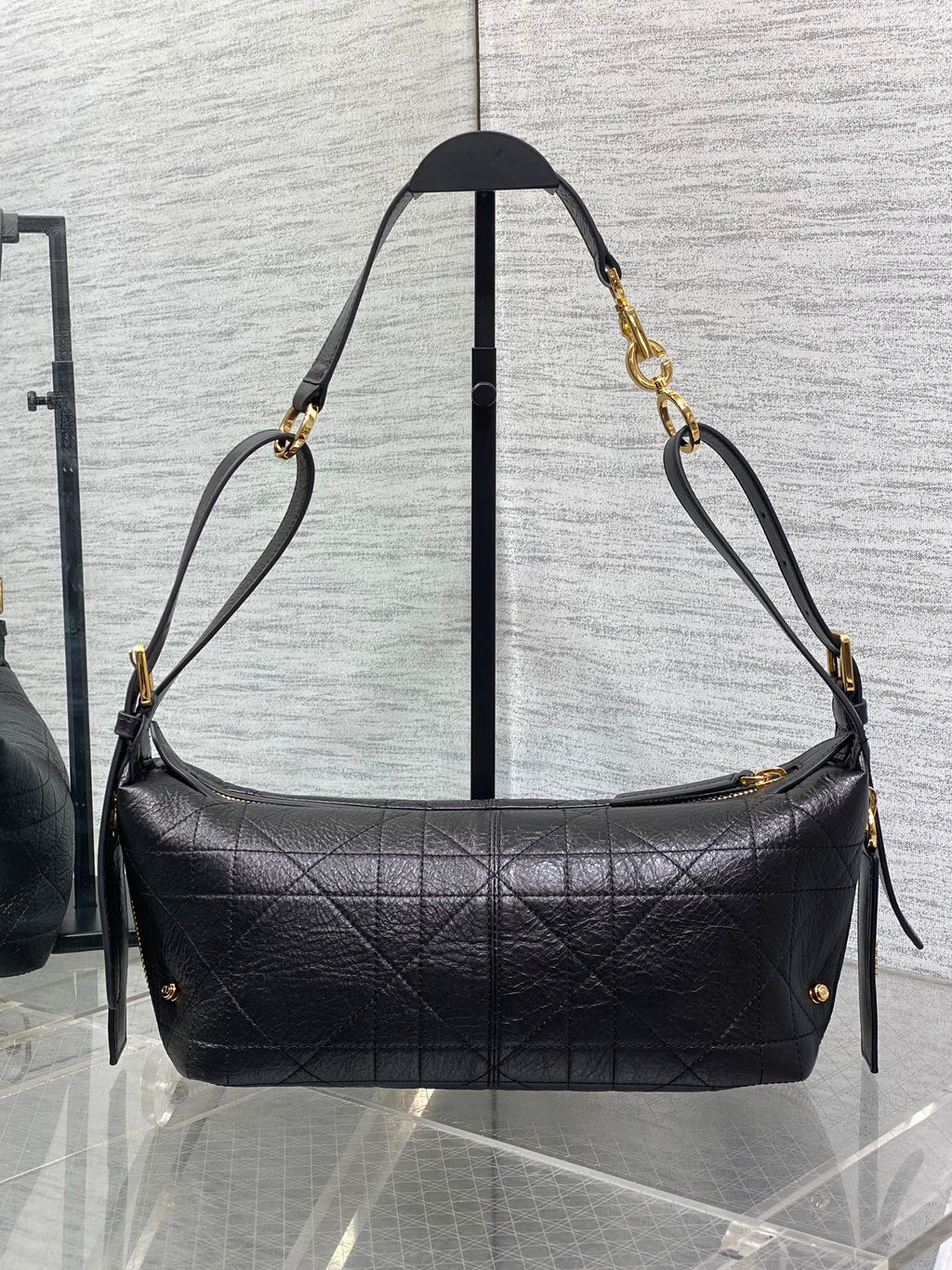 Black Dior hobo shoulder bag with quilted front, gold-tone chains, and ties