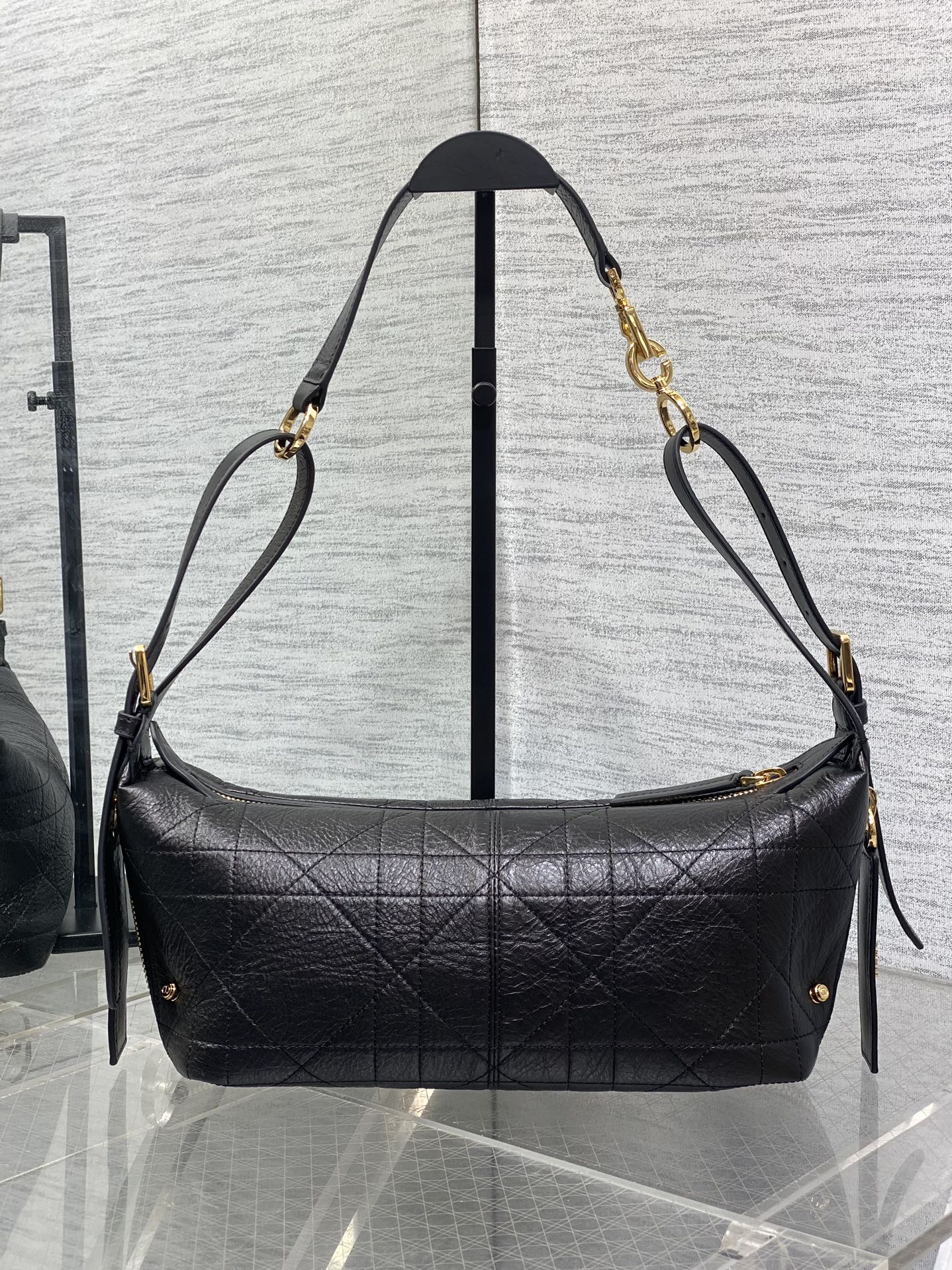 Black Dior hobo shoulder bag with quilted front, gold-tone chains, and ties