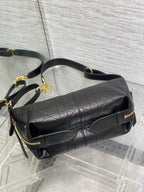 Black Dior leather crossbody bag with flap, gold-tone zipper, and chain strap