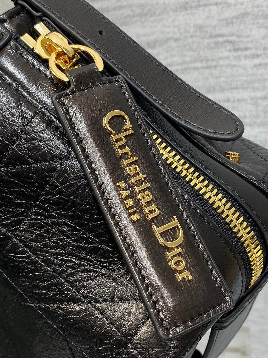 Black Dior leather zip pocket with gold-tone zipper and logo label