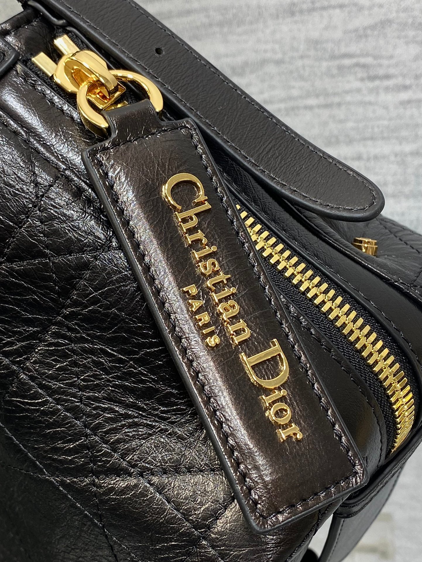 Black Dior leather zip pocket with gold-tone zipper and logo label