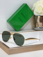 Bottega Veneta sunglasses with gold metal frame and dark green lenses