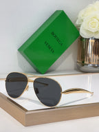 Bottega Veneta sunglasses with gold metal frame and dark lenses