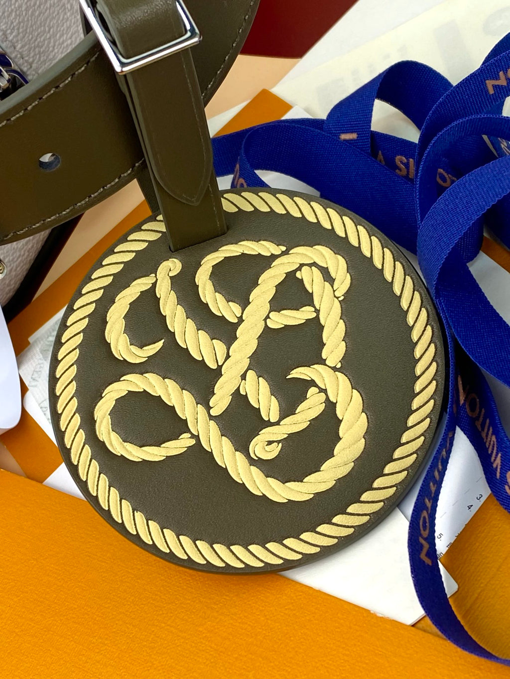 Louis Vuitton round monogram charm on green strap with gold rope edge