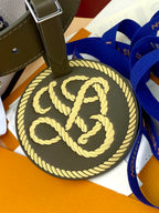Louis Vuitton round monogram charm on green strap with gold rope edge