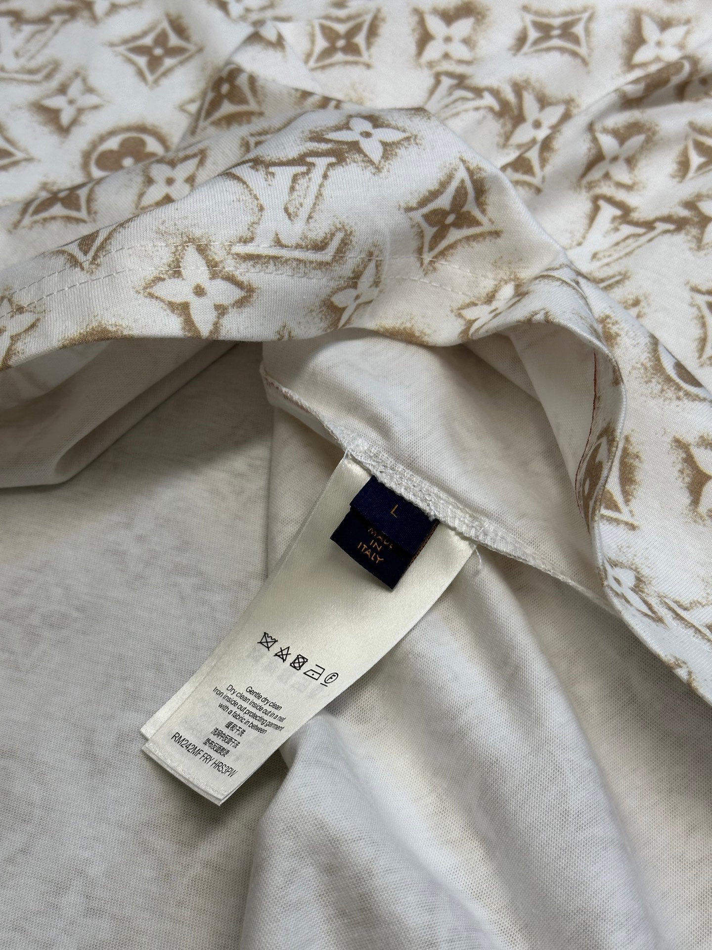 Cream T-shirt with gold monogram fabric, inner label and stitched neckline.
