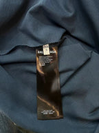 Blue T-shirt interior neck label with printed care text and woven tag.