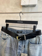 Light blue denim pants with black belt and gold buckle detail