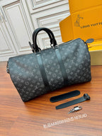 Men's Louis Vuitton duffel bag in dark gray monogram canvas with top handles and crossbody strap.