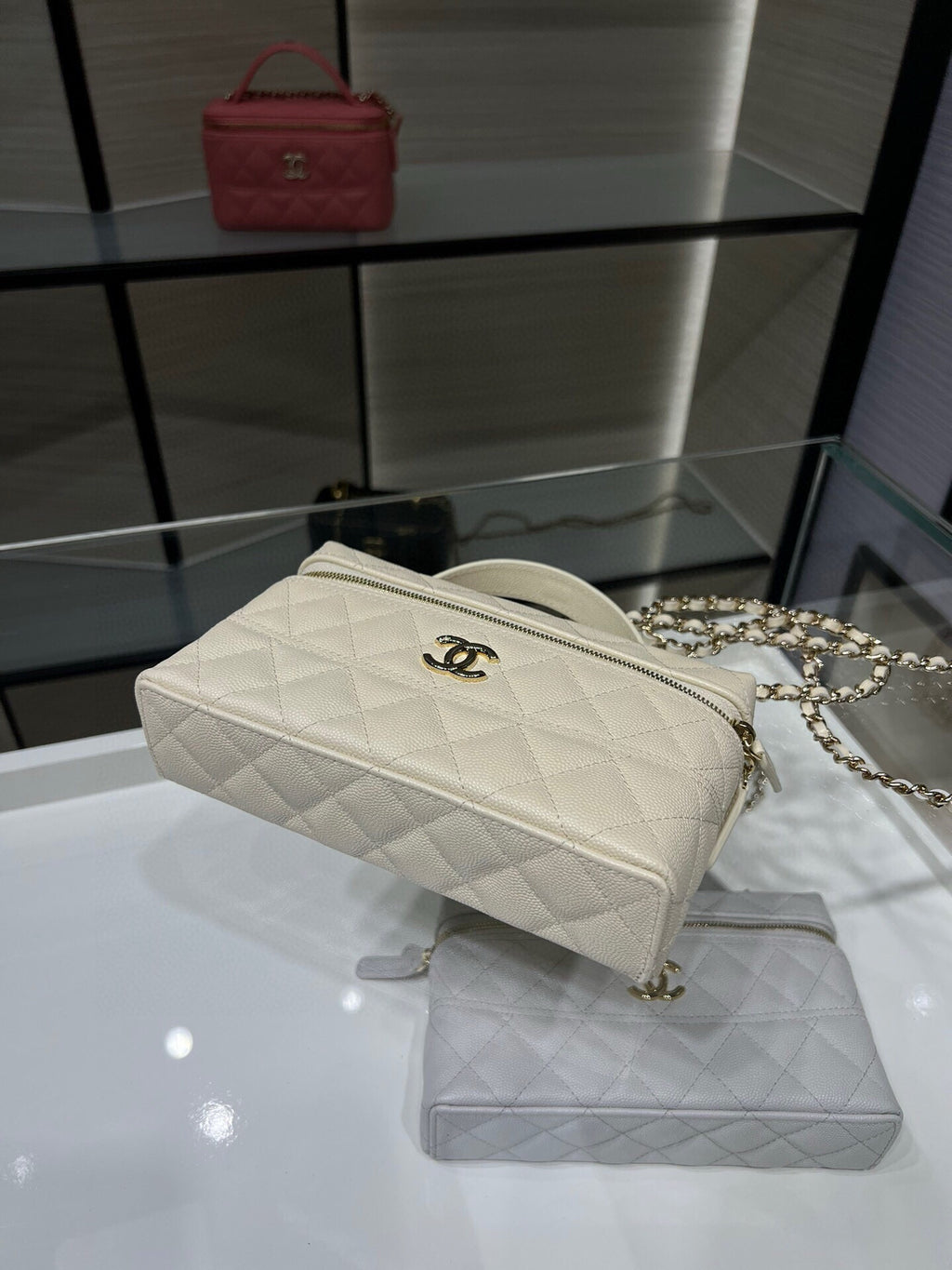 Quilted white Chanel crossbody bag with chain strap and top zipper