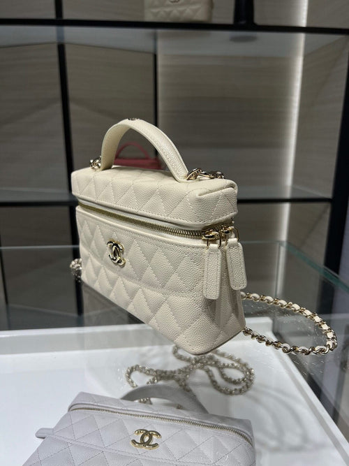 Small quilted white Chanel handbag with gold logo, zipper, and chain strap