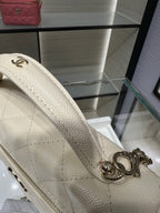 Textured white Chanel bag handle with interlocking ring detail and gold hardware