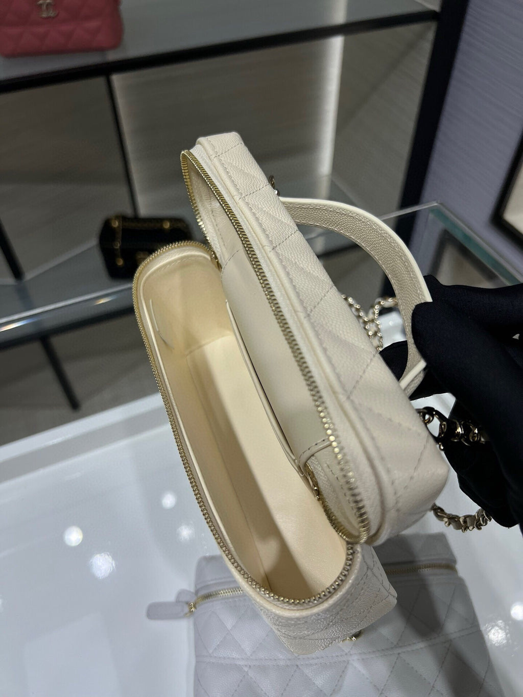 White Chanel bag with gold-trim zipper and chain shoulder strap