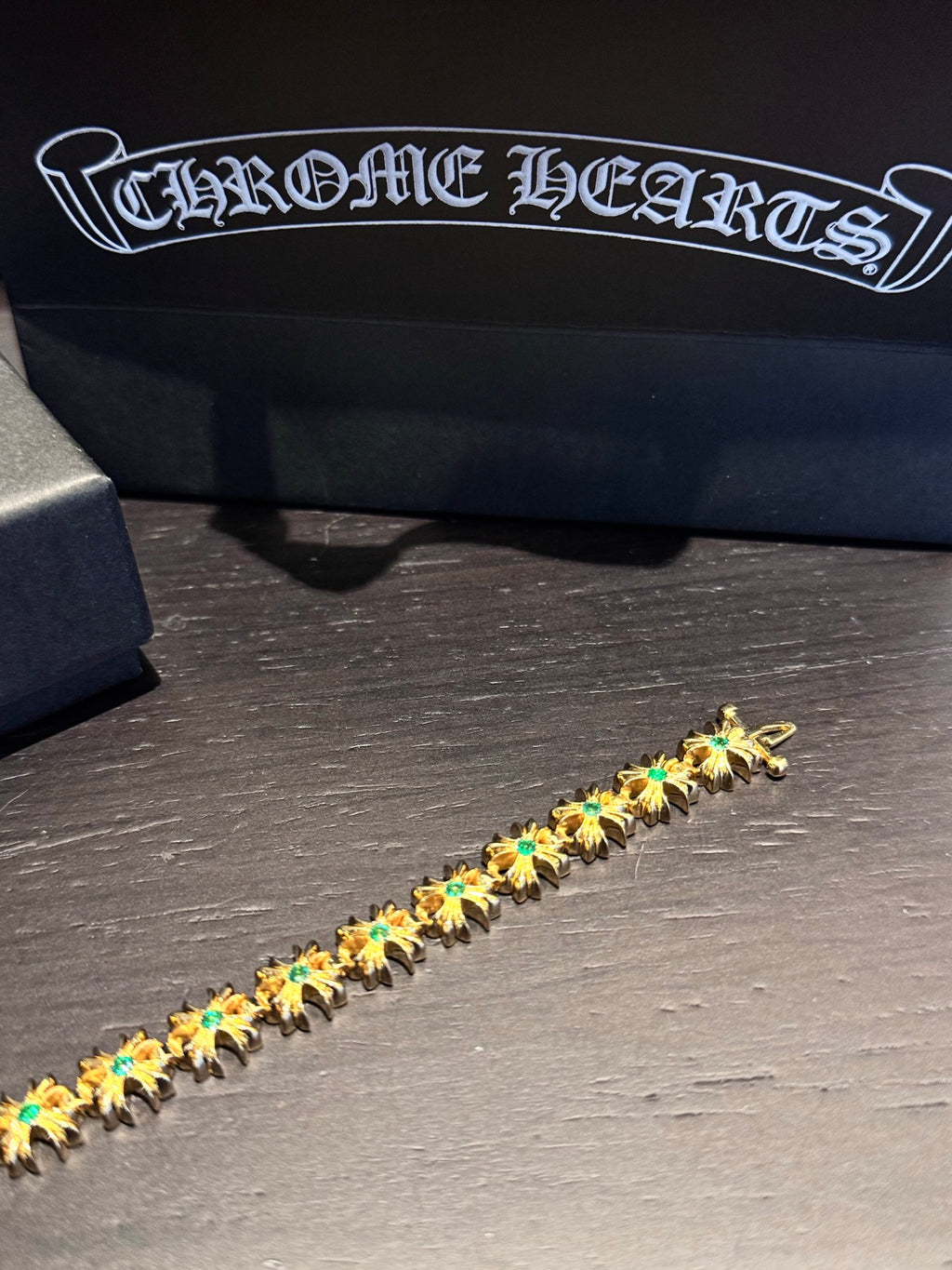 Gold-tone tennis bracelet with repeating teal-green stone clusters