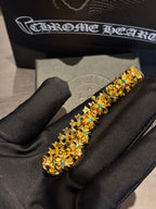 Gold-tone tennis-style bracelet with teal-green stones in ornate settings