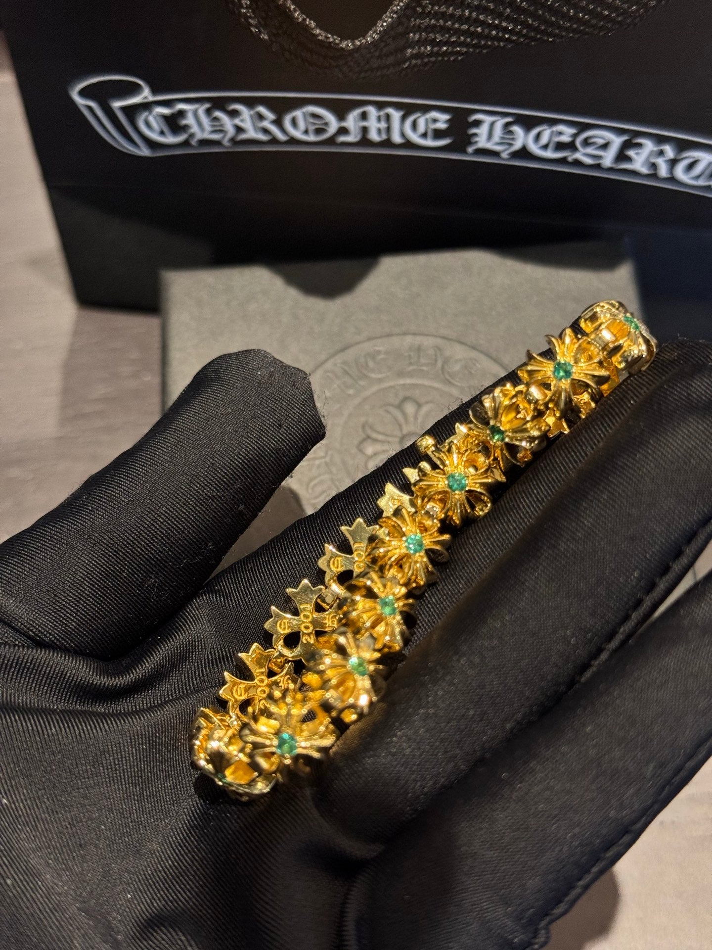 Gold-tone tennis-style bracelet with teal-green stones in ornate settings