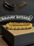 Gold-tone chain bracelet with green and teal gemstone links