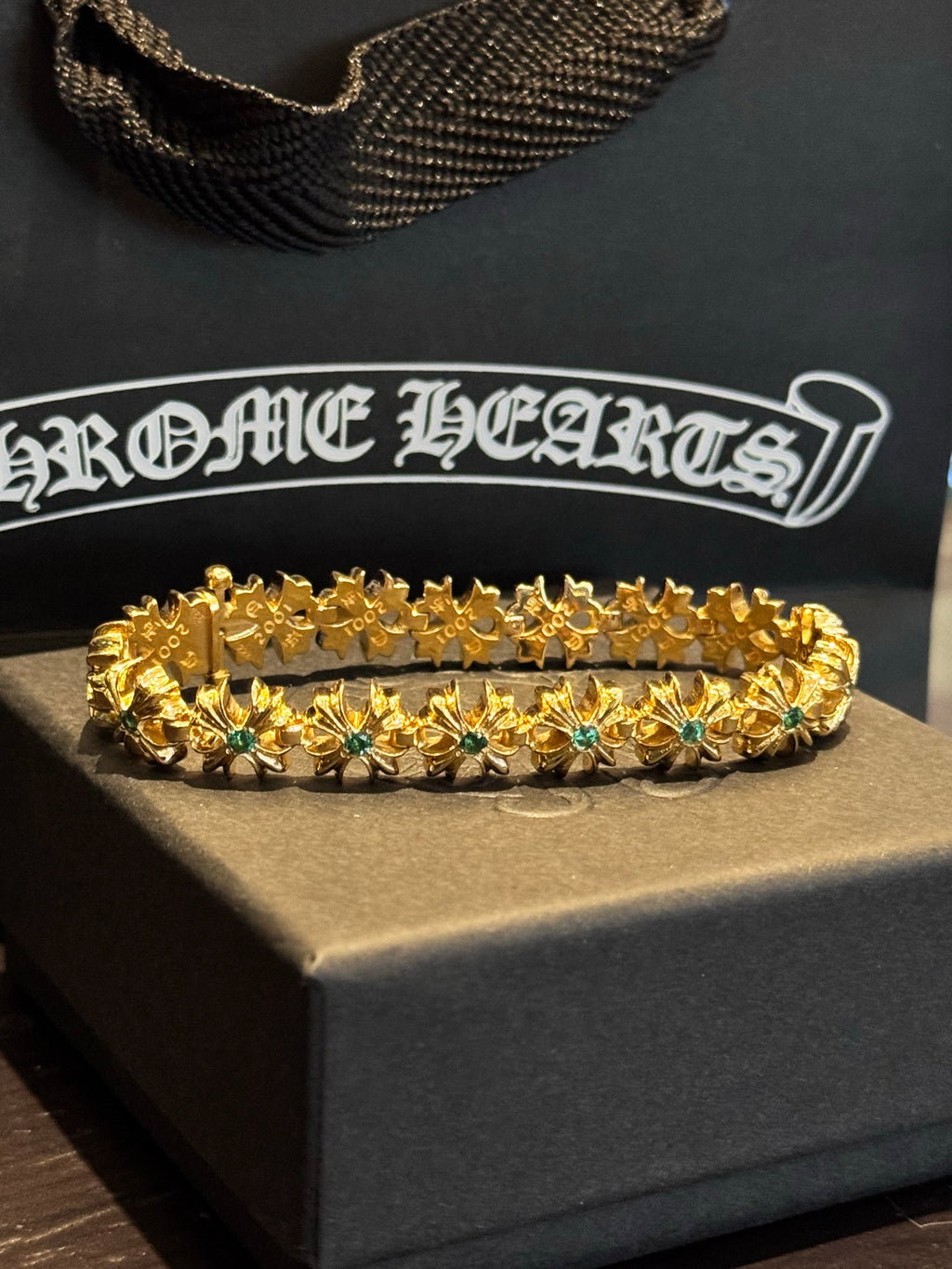 Gold-tone gemstone bracelet with scalloped links and teal-green stones