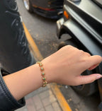 Gold-tone teal-stone link bracelet on wrist
