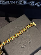 Gold-tone gemstone bracelet with teal stones set in gold star links