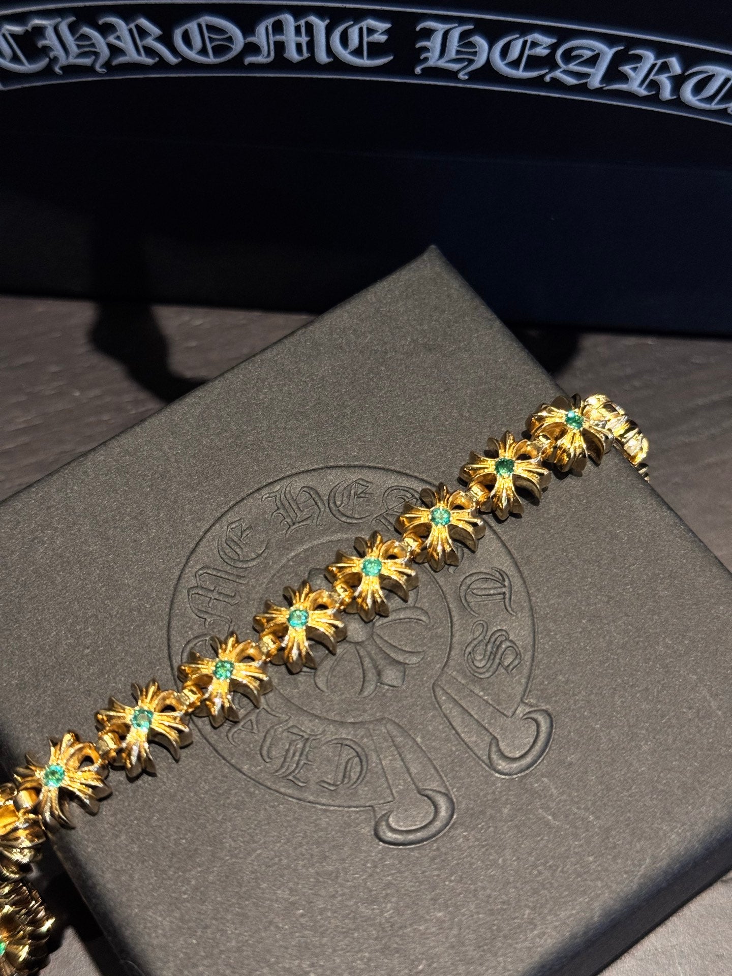 Gold-tone gemstone bracelet with teal stones set in gold star links