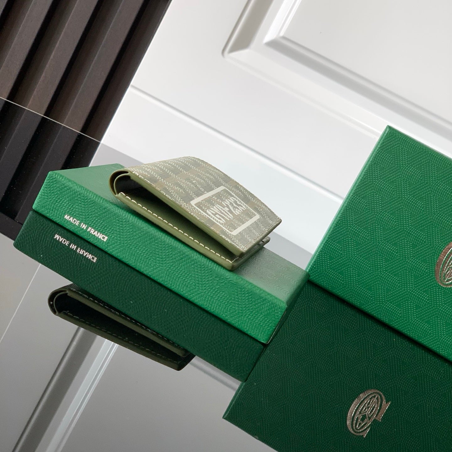 Green leather card holder with stitched trim and hanging loop