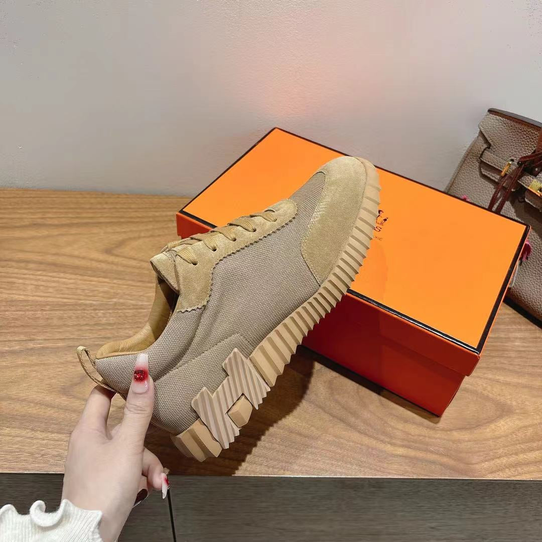 Beige sneaker on shoe box, showing lace-up front and ribbed sole