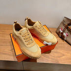 Hermes unisex beige lace-up sneakers, pair view with stitched toe cap and laces