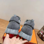 Gray suede sneakers rear view, cushioned collar and white ridged midsole