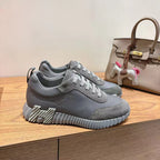 Gray suede lace-up sneakers with ridged sole, low-top design and stitched upper