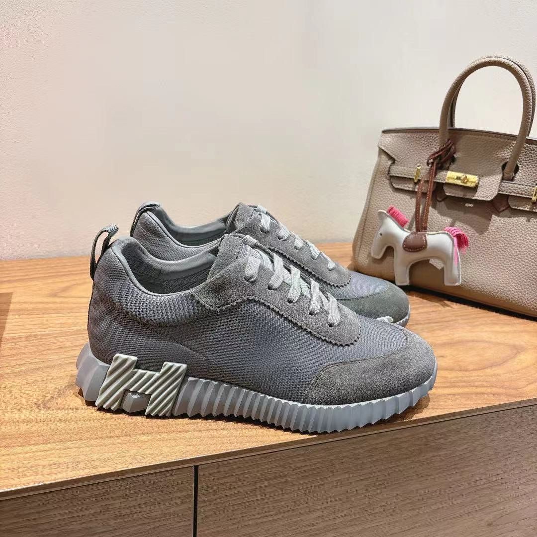 Gray suede lace-up sneakers with ridged sole, low-top design and stitched upper