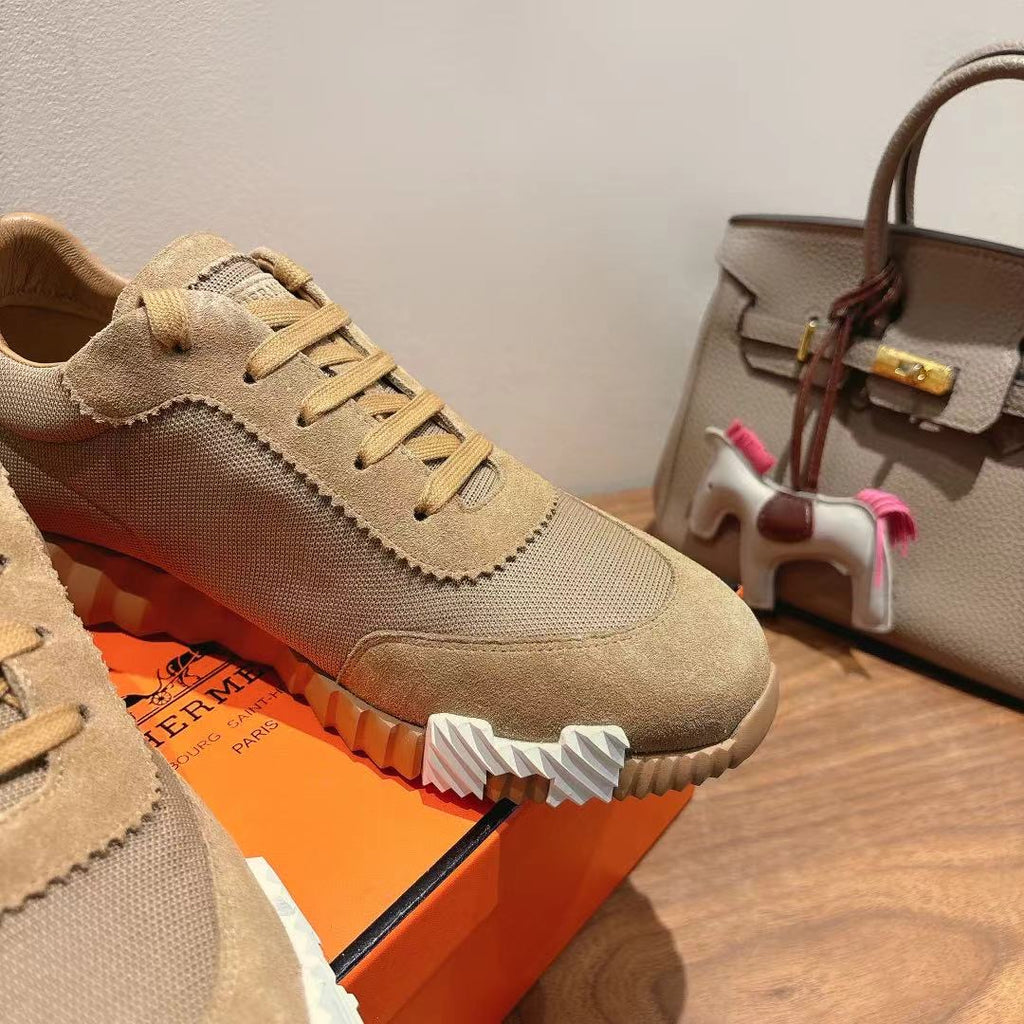Beige lace-up sneakers close-up with textured fabric, suede trim, and ridged sole