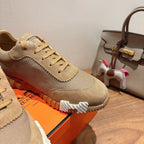 Beige lace-up sneakers close-up with textured fabric, suede trim, and ridged sole