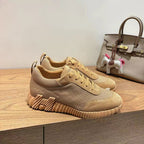 Beige low-top lace-up sneakers with textured side panel and chunky sole