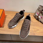 Grey suede lace-up sneakers, white textured sole and dark heel tab, Hermes