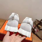 Hermes unisex white sneakers from heel view; high back and ribbed sole