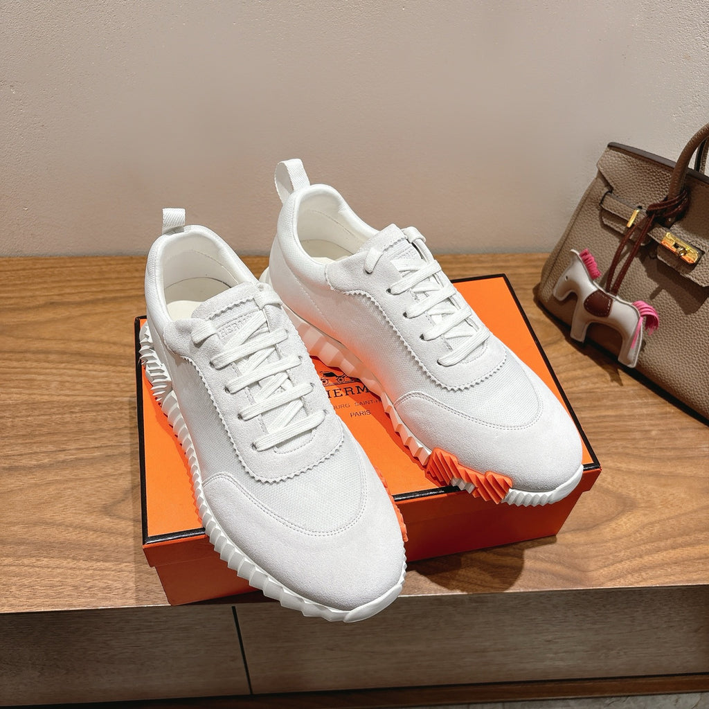Hermes unisex white sneakers on orange box; lace-up design and orange sole