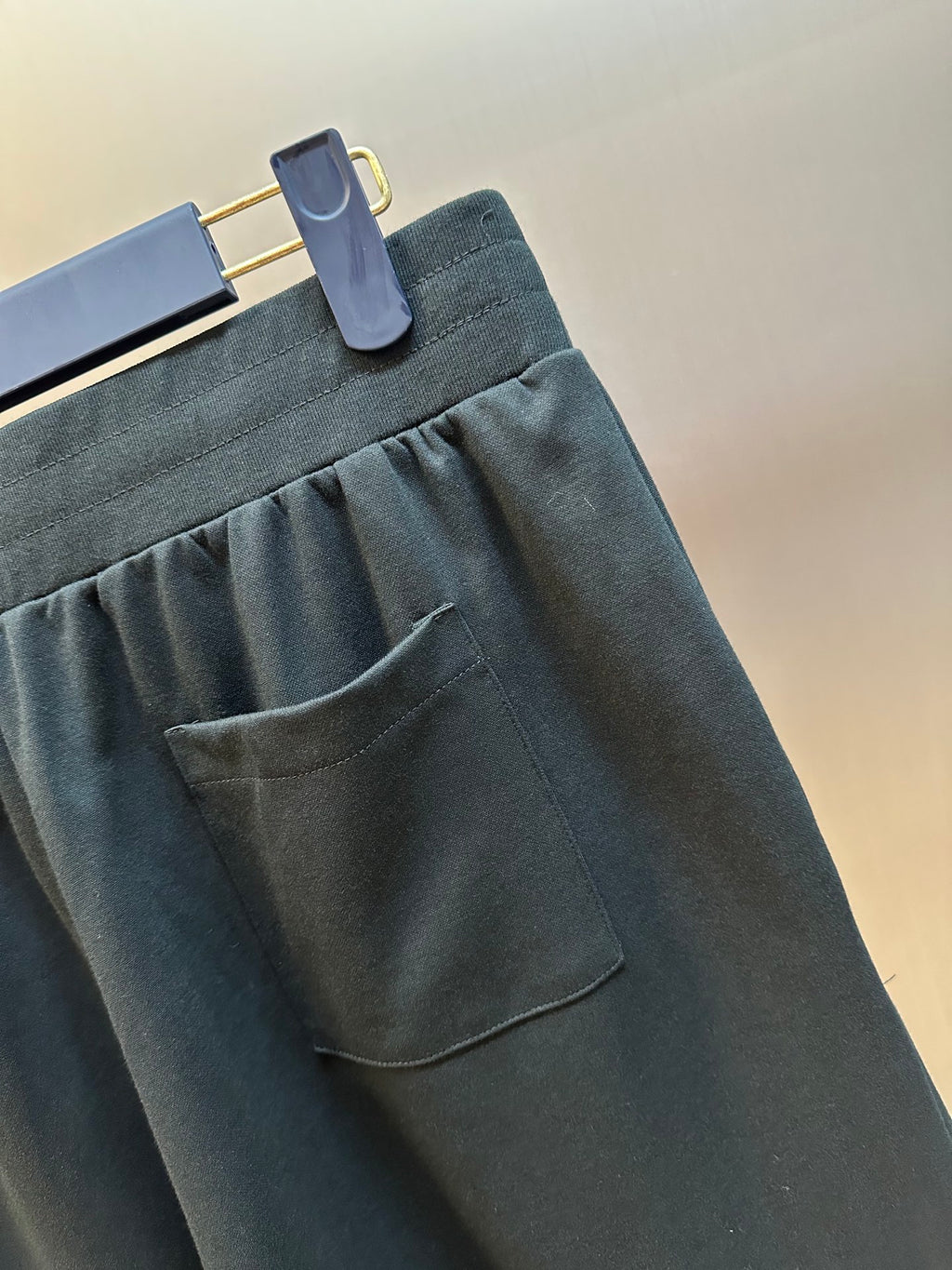 Louis Vuitton dark charcoal pants close-up of front pocket and pleats