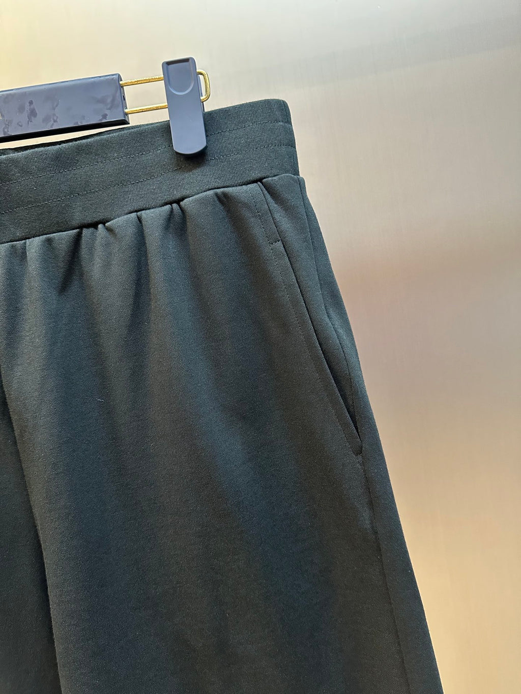 Louis Vuitton dark charcoal pants close-up of gathered front and pocket