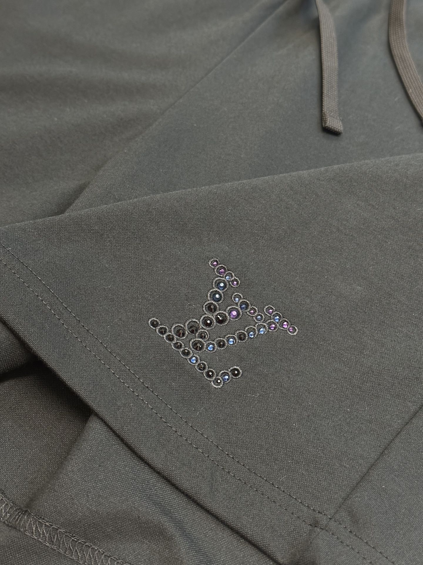 Louis Vuitton dark charcoal pants with beaded logo accent near pocket