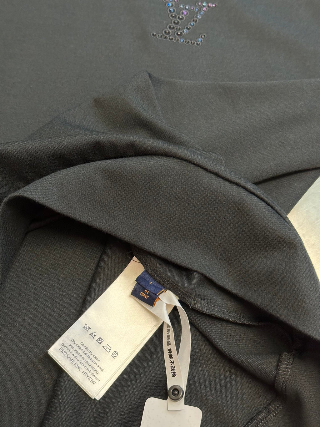 Dark charcoal sweatshirt collar and fabric folds with hang tag